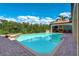 Beautiful pool and spa with lush landscaping and an outdoor pavilion featuring a fireplace at 109 Wateredge Ct, Safety Harbor, FL 34695