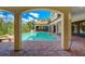 Resort-style pool area with covered pavilion featuring fireplace and seating for outdoor living at 109 Wateredge Ct, Safety Harbor, FL 34695