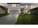 Charming two-story home with gray siding, a two-car garage, and a beautifully landscaped front yard at 11022 Moonsail Dr, Parrish, FL 34219