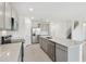 Open-concept kitchen with stainless steel appliances and a white countertop island, with a view of the staircase at 11022 Moonsail Dr, Parrish, FL 34219