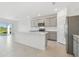 Modern kitchen with gray cabinets, stainless steel appliances, white countertops, and backyard view at 11022 Moonsail Dr, Parrish, FL 34219