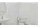 Bright powder room with white fixtures, including a pedestal sink and a toilet at 11022 Moonsail Dr, Parrish, FL 34219