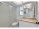 Clean bathroom featuring a glass shower door, white sink and vanity, and a large framed mirror at 11368 93Rd St, Largo, FL 33773