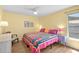 Bright bedroom with vibrant quilt, yellow walls, lots of natural light, and views of the outdoors at 11368 93Rd St, Largo, FL 33773