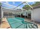 Inviting pool with ladder access, and a covered patio featuring a television and comfortable seating at 11368 93Rd St, Largo, FL 33773