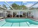 Enjoy the enclosed pool area with a covered patio, outdoor seating and a mounted television at 11368 93Rd St, Largo, FL 33773
