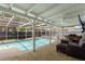 A sparkling pool in a screened enclosure is bordered by a covered patio with a seating area and outdoor grill at 11368 93Rd St, Largo, FL 33773