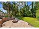 Backyard view featuring tropical landscaping and a brick fire pit at 12525 Sparkleberry Rd, Tampa, FL 33626