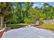 Backyard view featuring a deck, mulched garden, and lush landscaping with mature trees at 12525 Sparkleberry Rd, Tampa, FL 33626