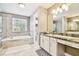 A spacious bathroom with dual sinks, a walk-in shower, a soaking tub, and great natural light at 12525 Sparkleberry Rd, Tampa, FL 33626