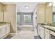 Luxurious bathroom featuring dual vanities, a separate shower, and a soaking tub beneath a bright window at 12525 Sparkleberry Rd, Tampa, FL 33626