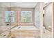 Elegant bathroom with soaking tub, walk-in shower, and natural light from a window at 12525 Sparkleberry Rd, Tampa, FL 33626