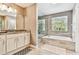 Bright bathroom featuring a soaking tub, glass enclosed shower, and granite counters at 12525 Sparkleberry Rd, Tampa, FL 33626