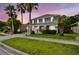 Charming two-story home featuring a three-car garage, landscaped yard, and palm trees against a picturesque sky at 12525 Sparkleberry Rd, Tampa, FL 33626