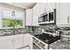 Well-lit kitchen featuring stainless steel appliances, granite countertops, and decorative tile backsplash at 12525 Sparkleberry Rd, Tampa, FL 33626