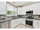 Updated kitchen with white cabinets, stainless steel appliances, and stone countertops, blending style with functionality at 12525 Sparkleberry Rd, Tampa, FL 33626