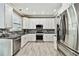 Well-equipped kitchen featuring stainless steel appliances, sleek white cabinets, and ample countertop space for cooking at 12525 Sparkleberry Rd, Tampa, FL 33626