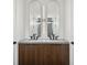 Stylish bathroom featuring double sinks with wood cabinetry and striking vertical mirrors with accent lighting at 1312 W Azeele St # 2, Tampa, FL 33606