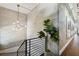 Upstairs landing showing staircase, modern chandelier, and concrete block wall at 1312 W Azeele St # 2, Tampa, FL 33606