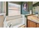 This bathroom features a soaking tub beneath a frosted window next to a countertop vanity at 1318 Crimson Clover Ln, Wesley Chapel, FL 33543