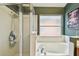 This bathroom features a glass enclosed shower with bathtub beneath a frosted window at 1318 Crimson Clover Ln, Wesley Chapel, FL 33543