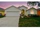 Charming single-story home featuring a well-manicured lawn and attached two-car garage at 1318 Crimson Clover Ln, Wesley Chapel, FL 33543