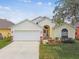 Charming single-story home with a well-manicured lawn, a two-car garage, and beautiful landscaping at 1318 Crimson Clover Ln, Wesley Chapel, FL 33543