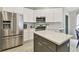 Kitchen with stainless steel appliances, white cabinets, and a gray kitchen island at 1318 Crimson Clover Ln, Wesley Chapel, FL 33543