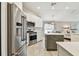 Bright kitchen features white cabinets, stainless steel appliances, and a center island at 1318 Crimson Clover Ln, Wesley Chapel, FL 33543