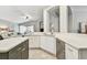 Bright, open kitchen featuring white cabinetry, stainless steel appliances, and speckled quartz countertops at 1318 Crimson Clover Ln, Wesley Chapel, FL 33543
