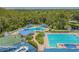 Aerial view of a community pool area, featuring multiple pools and lounging areas at 1318 Crimson Clover Ln, Wesley Chapel, FL 33543