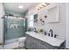 Modern bathroom featuring double sinks, updated vanity, a glass shower, and tiled walls at 1601 14Th W St, Palmetto, FL 34221