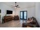 Living room with a ceiling fan, tv, wood look floors, and French doors that provide plenty of natural light at 1601 14Th W St, Palmetto, FL 34221