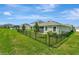 Well-maintained backyard with green lawn and black metal fence; perfect outdoor space at 16633 Mooner Plank Cir, Wimauma, FL 33598