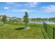 A wrought iron fence encloses a backyard, creating a secure space with serene lake views at 16633 Mooner Plank Cir, Wimauma, FL 33598