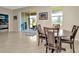 Bright dining area with sliding doors to the patio, wood table and chairs, and tile flooring at 16633 Mooner Plank Cir, Wimauma, FL 33598