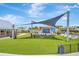 Lush green event lawn with shade structures, stage, and entertainment area, perfect for community gatherings at 16633 Mooner Plank Cir, Wimauma, FL 33598