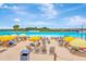 Breathtaking lagoon view featuring a sandy beach area with lounge chairs and yellow umbrellas for a relaxing experience at 16633 Mooner Plank Cir, Wimauma, FL 33598