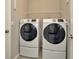 Bright laundry room with two new Samsung washer and dryer units with pedestal bases at 16633 Mooner Plank Cir, Wimauma, FL 33598