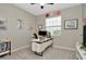 Bright office space with a modern desk, neutral walls, plush carpeting, and natural light from the window at 16633 Mooner Plank Cir, Wimauma, FL 33598