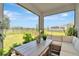 Relaxing covered patio with comfortable seating and scenic views of the backyard and surrounding area at 16633 Mooner Plank Cir, Wimauma, FL 33598