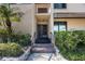 Close-up of front door with charming details and access to a welcoming condo featuring verdant landscaping at 2205 Belleair Rd # A24, Clearwater, FL 33764
