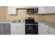 Close-up of modern kitchen appliances, including a stainless steel microwave and glass-top stove at 2205 Belleair Rd # A24, Clearwater, FL 33764
