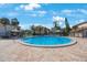 Community pool surrounded by tropical landscaping at 2205 Belleair Rd # A24, Clearwater, FL 33764