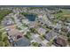 Aerial view of a residential neighborhood with landscaped yards and a pond at 2310 Wood Pointe Dr, Holiday, FL 34691
