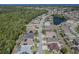 Aerial view of a residential neighborhood with pond and mature trees at 2310 Wood Pointe Dr, Holiday, FL 34691