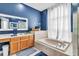 Bathroom featuring a large soaking tub, wood cabinets and blue accent wall at 2310 Wood Pointe Dr, Holiday, FL 34691