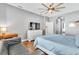 The primary bedroom offers a ceiling fan, hardwood floors, and a comfortable seating area at 2310 Wood Pointe Dr, Holiday, FL 34691