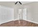 Bedroom featuring wood floor, ceiling fan and white closet doors at 2310 Wood Pointe Dr, Holiday, FL 34691