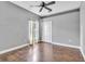 Bedroom with wood floor, ceiling fan and white closet doors at 2310 Wood Pointe Dr, Holiday, FL 34691